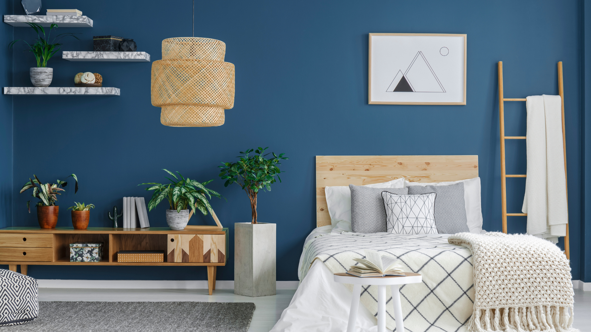 Chambre avec murs bleus, mobilier en bois et linge de lit
